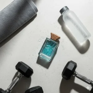 A flat-lay of gym gear and a bottle of aquatic cologne for men, highlighting its use as a clean, post-workout scent.
